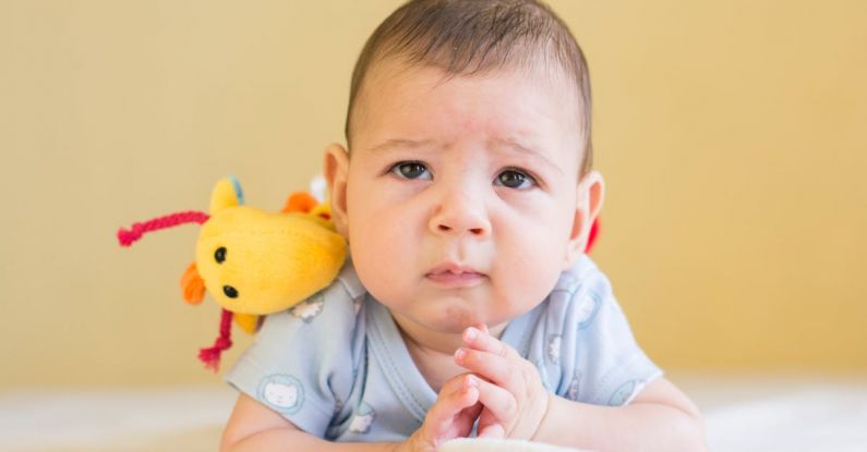 Milestones - Baby in Blue Shirt Lying on Bed